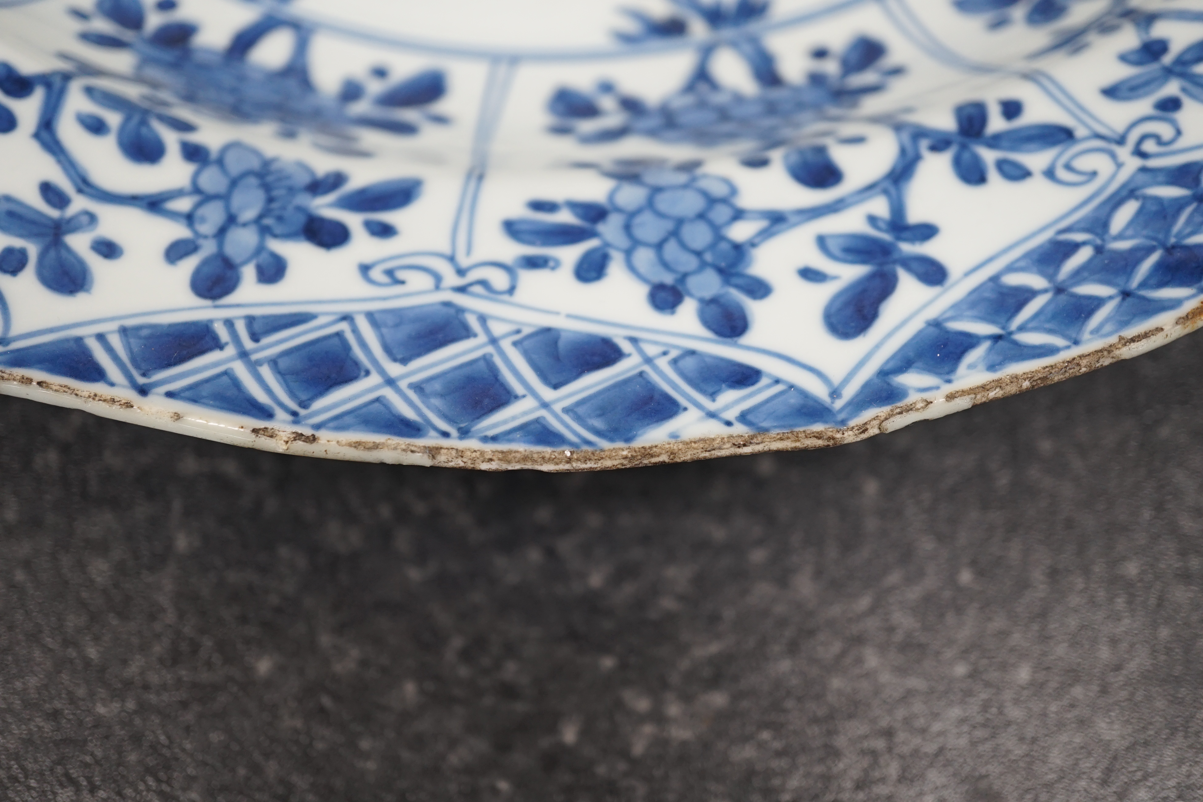 A pair of Chinese blue and white ‘garden’ dishes, Kangxi period, fritting and glaze chips